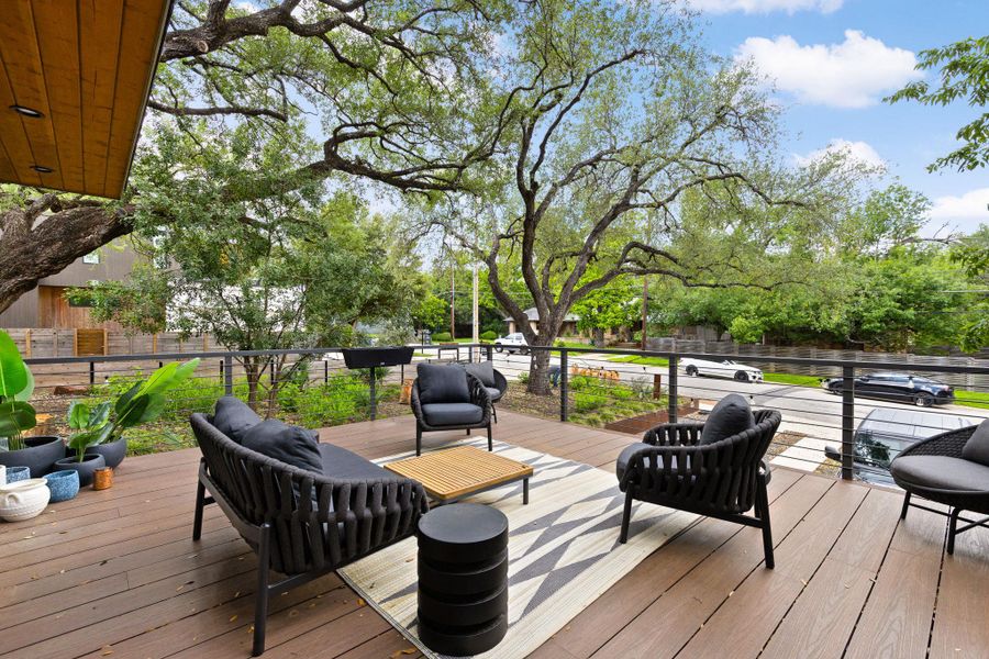 An inviting outdoor living space features a spacious wooden deck with comfortable seating, offering serene views of mature trees and the neighborhood. An inviting outdoor living space features a spacious wooden deck with comfortable seating, offering serene views of mature trees and the neighborhood.