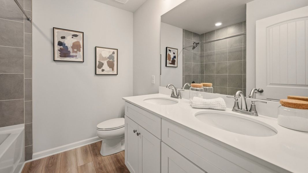 Secondary bathroom with dual vanity and tiled shower Secondary bathroom with dual vanity and tiled shower