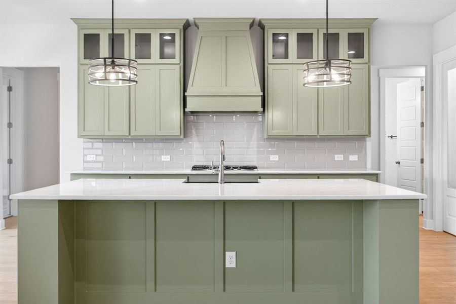 Kitchen island with a light-toned countertop and paneled base, complemented by matching cabinetry Kitchen island with a light-toned countertop and paneled base, complemented by matching cabinetry