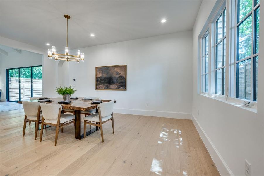Dining room featuring a chandelier, light wood-style flooring, and recessed lighting