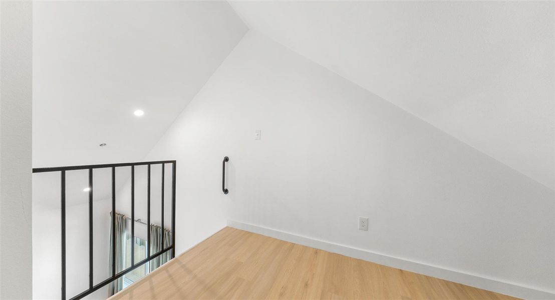 A loft landing with warm wood floors — bonus space for a reading corner, a studio, or a quiet escape. Model No. 105 Shown.