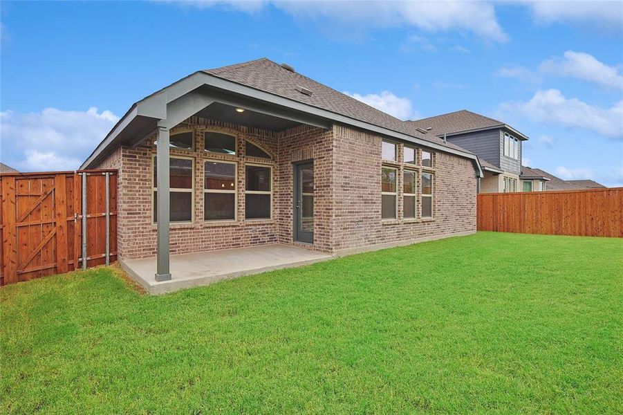 Back of house with a patio area and a lawn