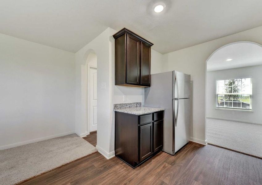 Frio kitchen counter with stainless steel refrigerator and archway entry to dining room