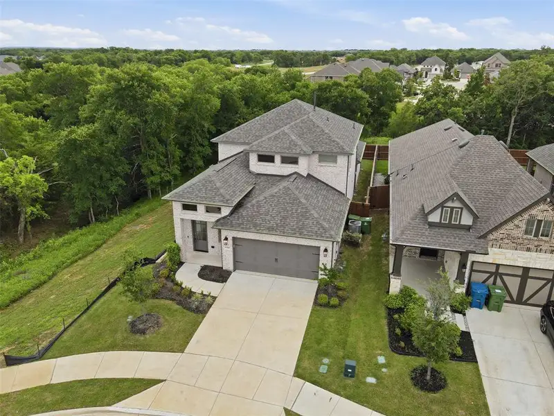 Front exterior of a new home in Prairie Oaks, Oak Point, TX, highlighting curb appeal (Image 2). Front exterior of a new home in Prairie Oaks, Oak Point, TX, highlighting curb appeal (Image 2).