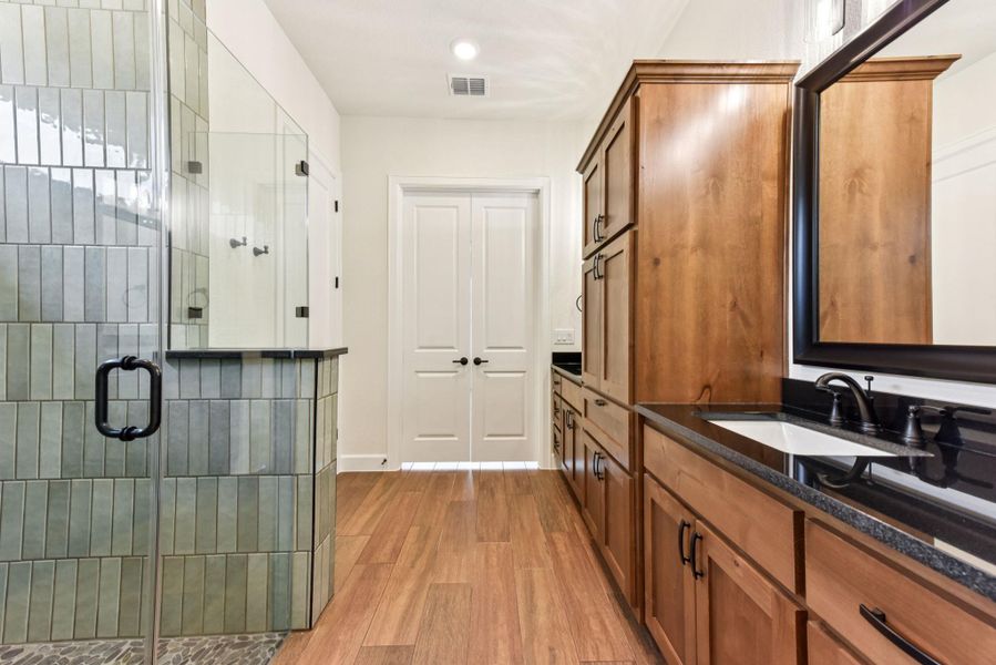 Full bathroom with vanity, light wood finished floors, a shower stall, and recessed lighting