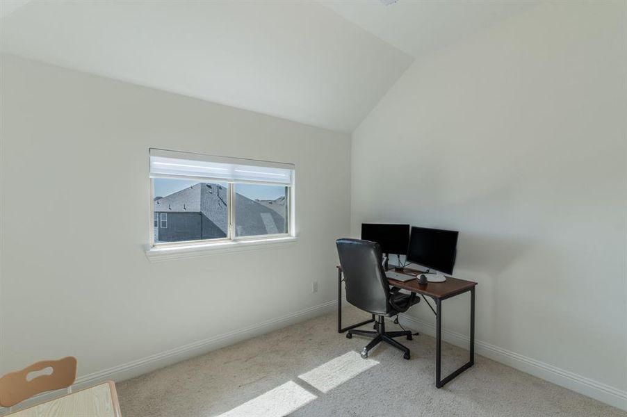 Carpeted room featuring a single window with blinds and an angled ceiling line