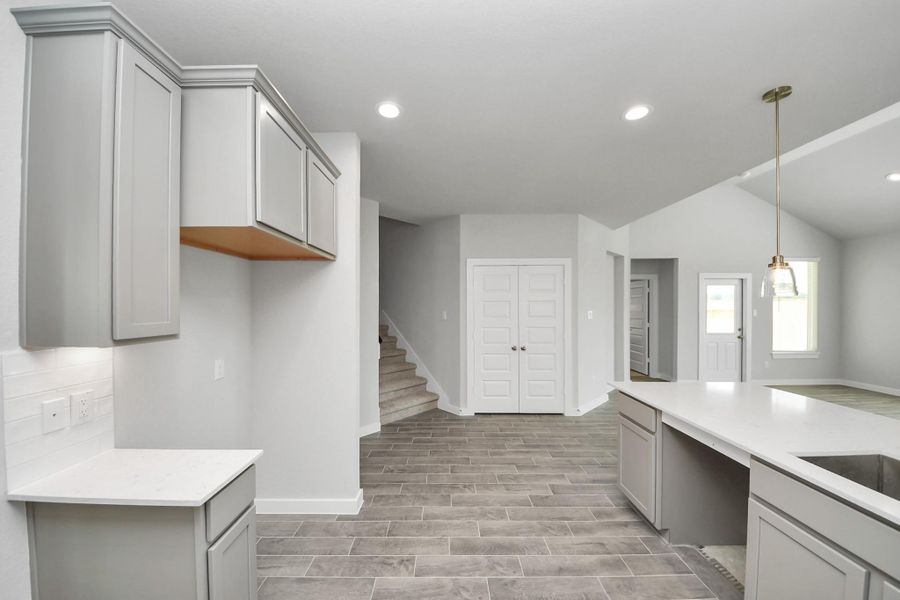 Discover another perspective of this stunning kitchen, generously appointed with an abundance of counter space. Sample photo of completed home with similar floor plan. Actual colors and selections may vary. Discover another perspective of this stunning kitchen, generously appointed with an abundance of counter space. Sample photo of completed home with similar floor plan. Actual colors and selections may vary.