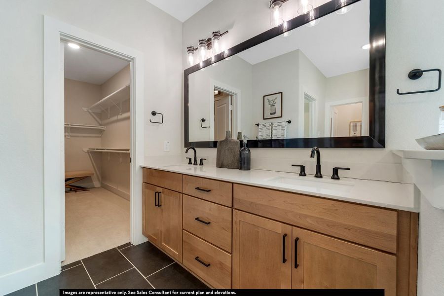 Full bathroom featuring double vanity, dark tile patterned floors, and a spacious closet Full bathroom featuring double vanity, dark tile patterned floors, and a spacious closet