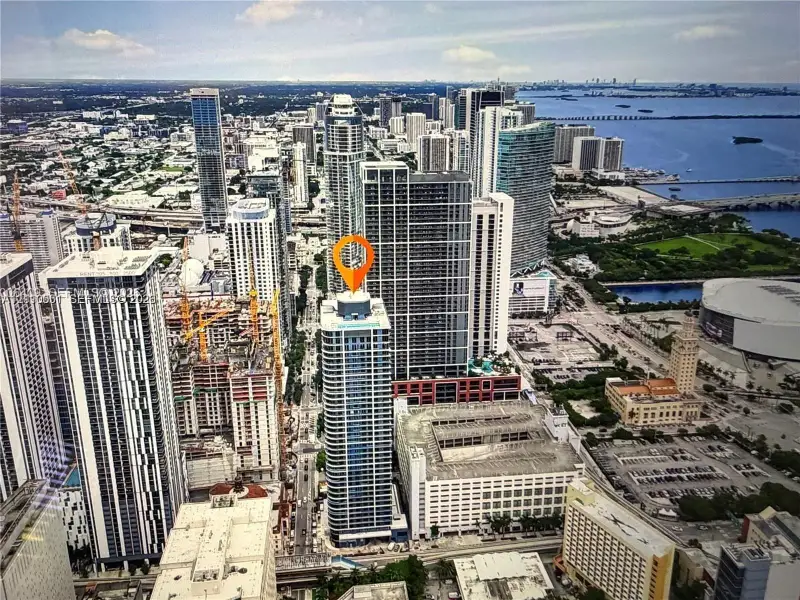 High-rise tower featuring a glass facade, expansive urban scenery, and water frontage