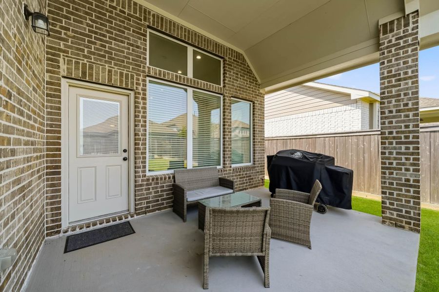 The covered patio features a tall ceiling and is pre-wired for a ceiling fan, creating an inviting outdoor retreat ideal for relaxing, dining or entertaining in comfort.