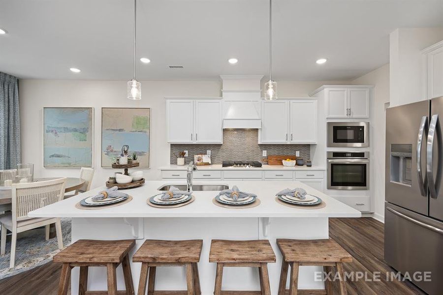 Kitchen featuring white cabinets, hanging light fixtures, sink, dark hardwood / wood-style floors, and appliances with stainless steel finishes