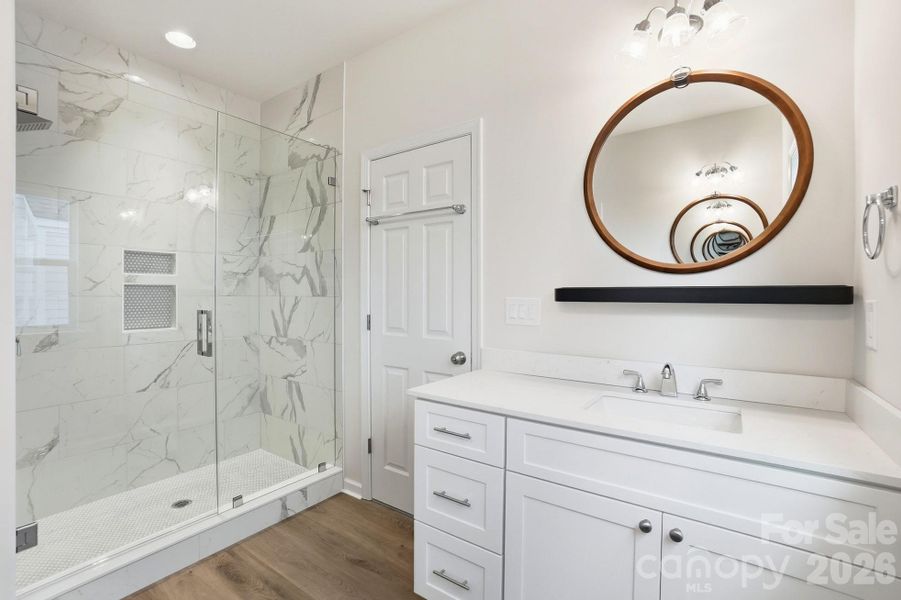 Primary bath with dual vanities and walk-in tile shower