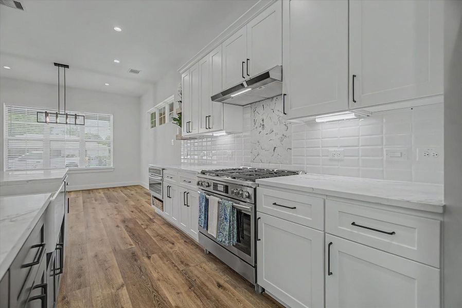 Custom kitchen featuring soft-close cabinetry, drawers, and integrated under-cabinet lighting.