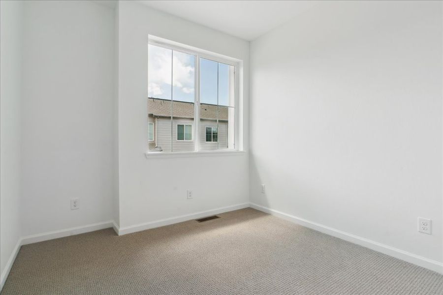 A room with a window and a carpet.