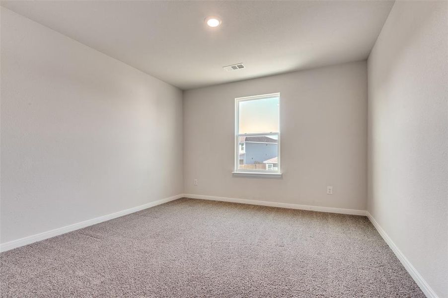 Empty room featuring light carpet and baseboards