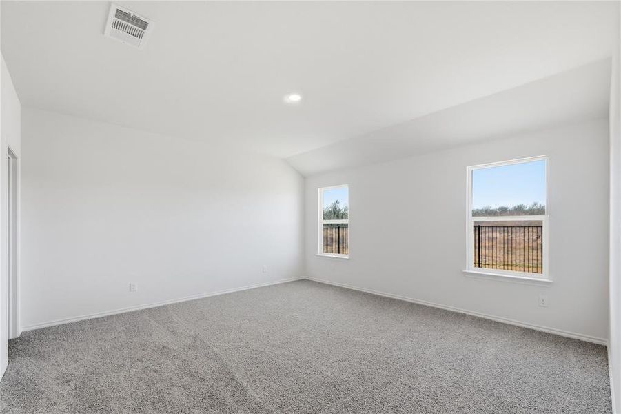 Spacious interior room featuring light gray carpeting and white painted walls