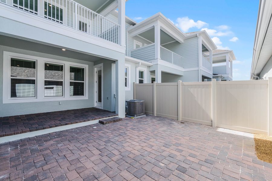 Exterior details and patio area of a home in Harvest at Ovation - Townhomes, Winter Garden (Image 17).