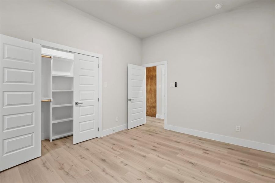 Unfurnished bedroom featuring light hardwood / wood-style floors and a closet