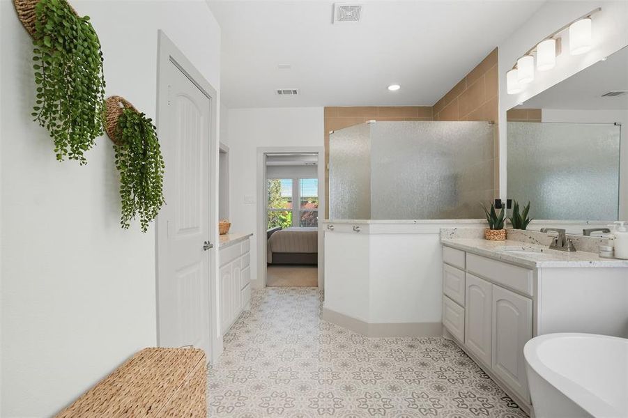 Full bath featuring ensuite bath, vanity, a shower stall, and a freestanding tub Full bath featuring ensuite bath, vanity, a shower stall, and a freestanding tub