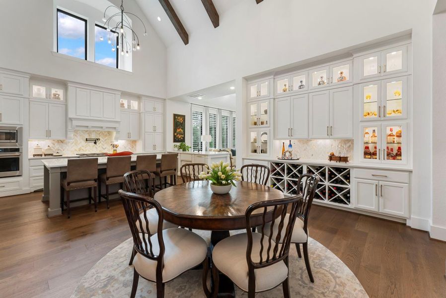 The dining area feels defined yet connected, offering a comfortable place to gather within the open plan. Custom cabinetry, upgraded lighting, and ceiling details create a more elevated everyday dining experience.