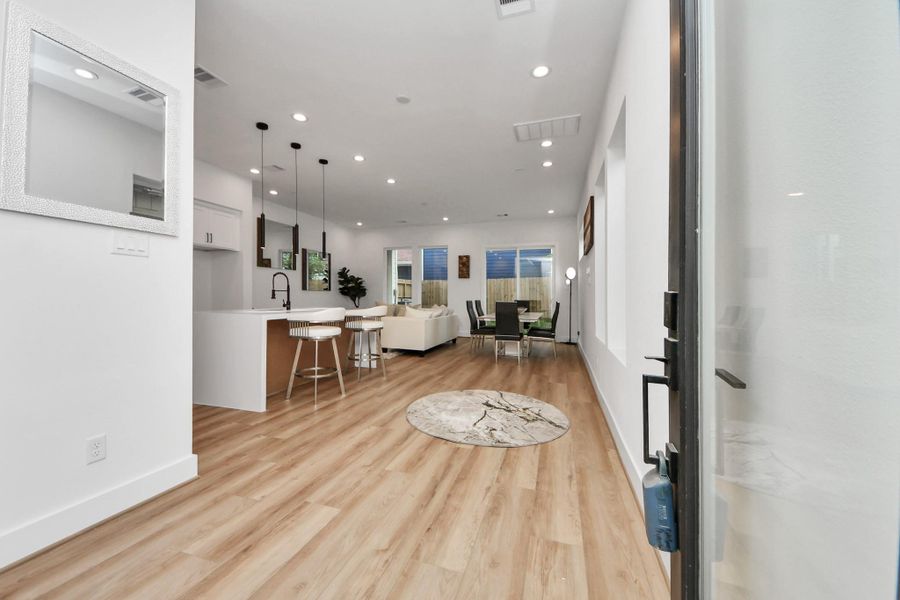 Welcome to your new home: step into a bright, open-concept space featuring sleek hardwood floors, a modern kitchen with chic pendant lighting, and a cozy living area perfect for entertaining.