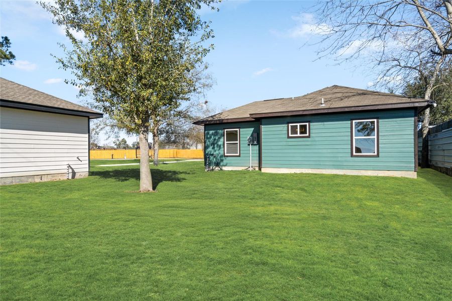 Rear exterior view highlighting the home’s fresh construction and spacious lot.