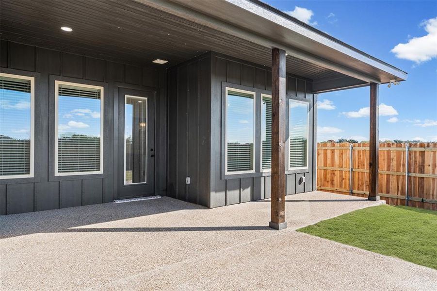 Property entrance with a patio and board and batten siding