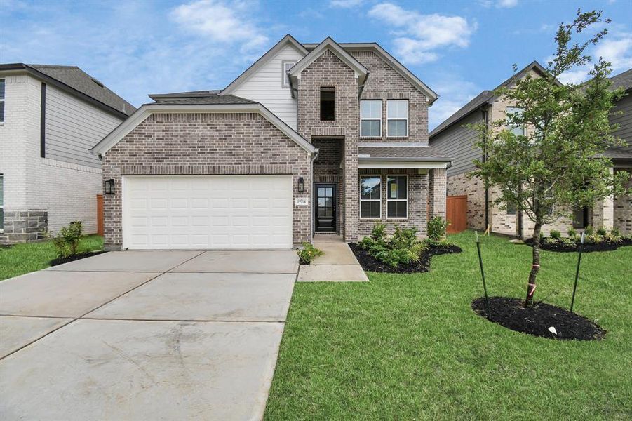 Meticulously maintained yard and lush landscape, paired with a premium elevation featuring captivating brick accents. Modern coach lights add a touch of contemporary elegance to the exterior.