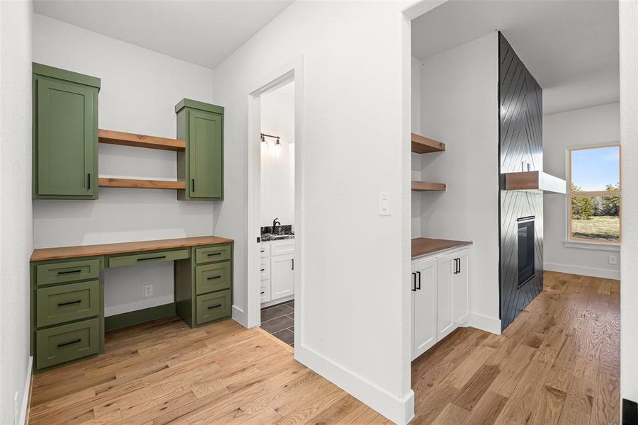 Secondary office space featuring light wood-type flooring, butcher block countertops, and green cabinets