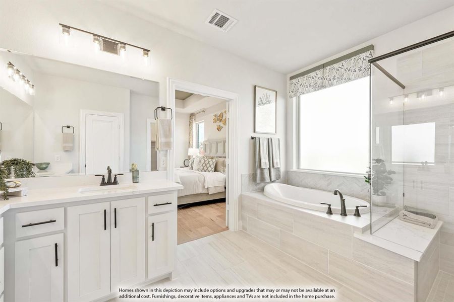Master bathroom with white double vanity, soaking tub, and glass shower enclosure
