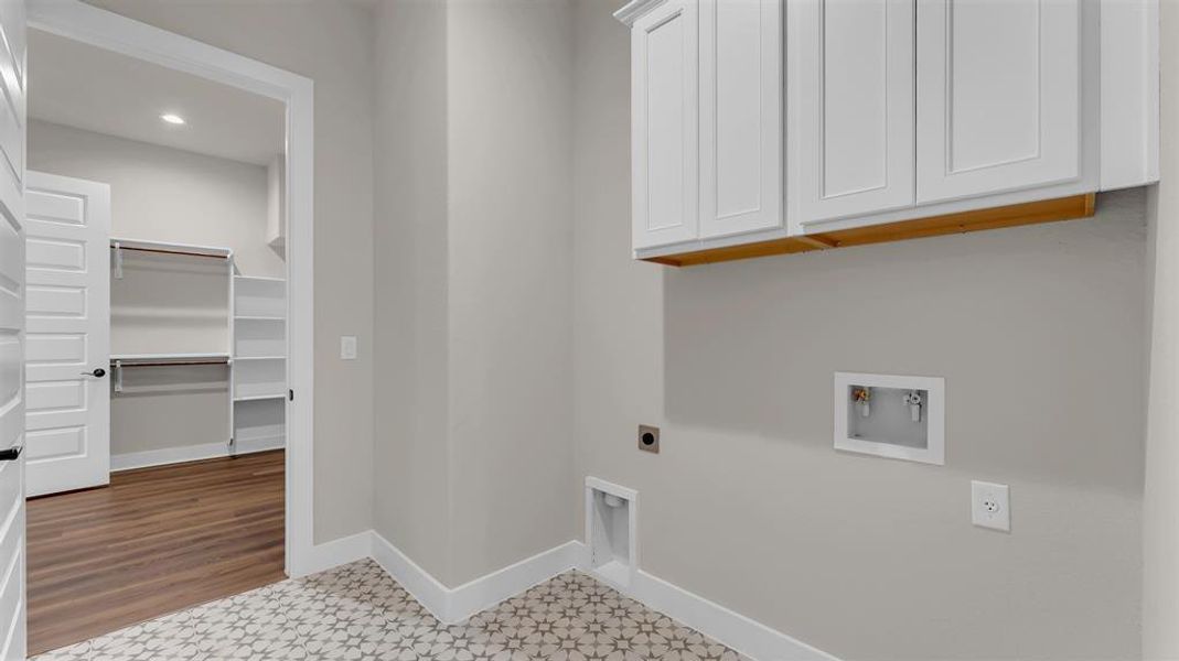 Patterned floor tile and built-in white cabinetry elevate this functional utility space. Patterned floor tile and built-in white cabinetry elevate this functional utility space.