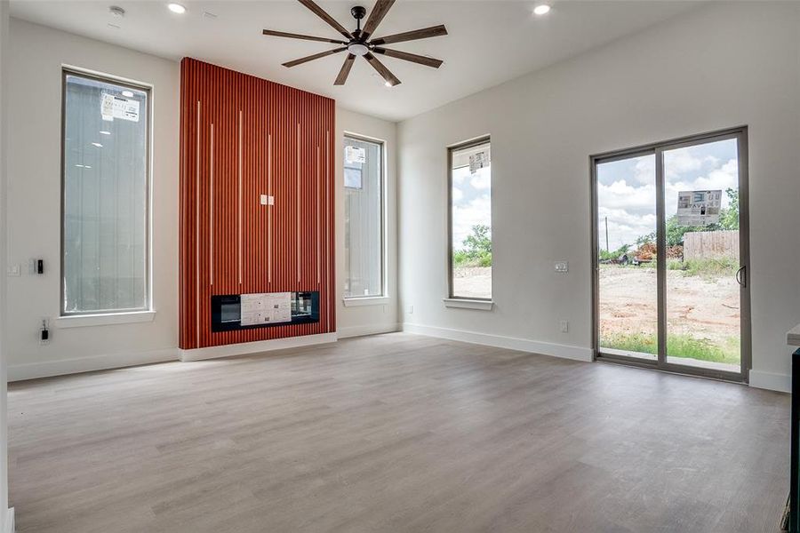Unfurnished living room with ceiling fan, wood finished floors, and recessed lighting Unfurnished living room with ceiling fan, wood finished floors, and recessed lighting