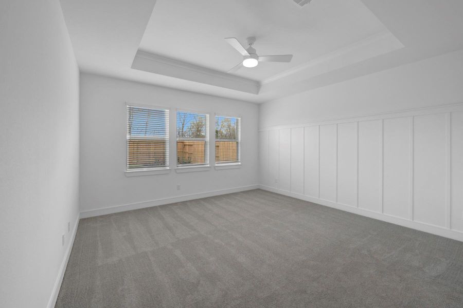 Spacious primary suite with decorative feature wall