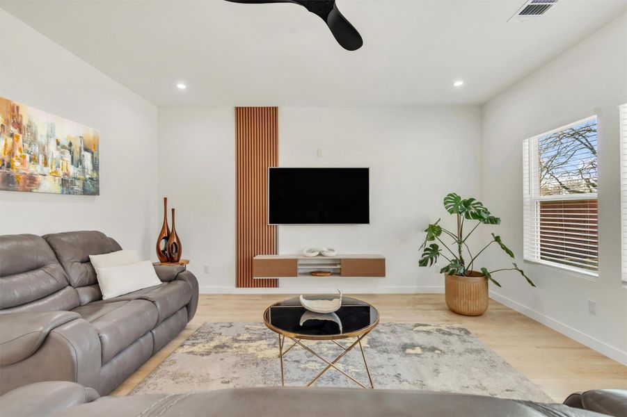 Living room with ceiling fan, light wood finished floors, and recessed lighting