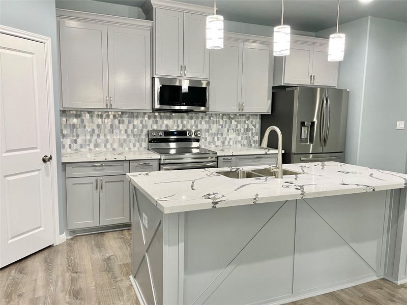 Culinary delights await in this modern kitchen, featuring sleek stainless steel appliances and a spacious center island.