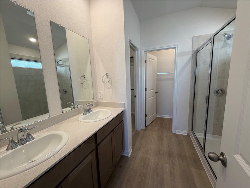Full bath with a stall shower, dark wood-type flooring, and double vanity Full bath with a stall shower, dark wood-type flooring, and double vanity