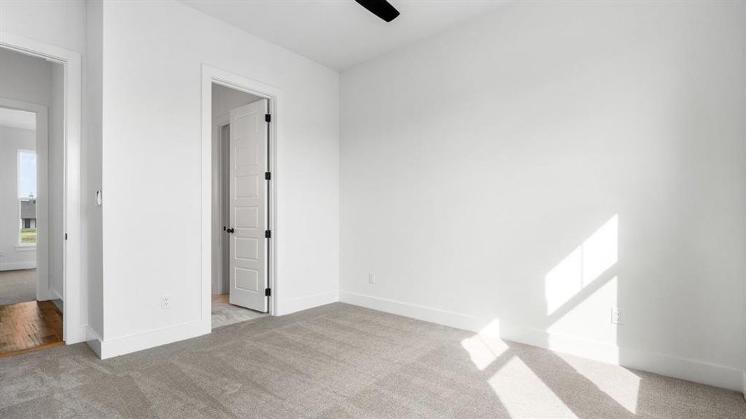 Unfurnished bedroom featuring ceiling fan and light colored carpet