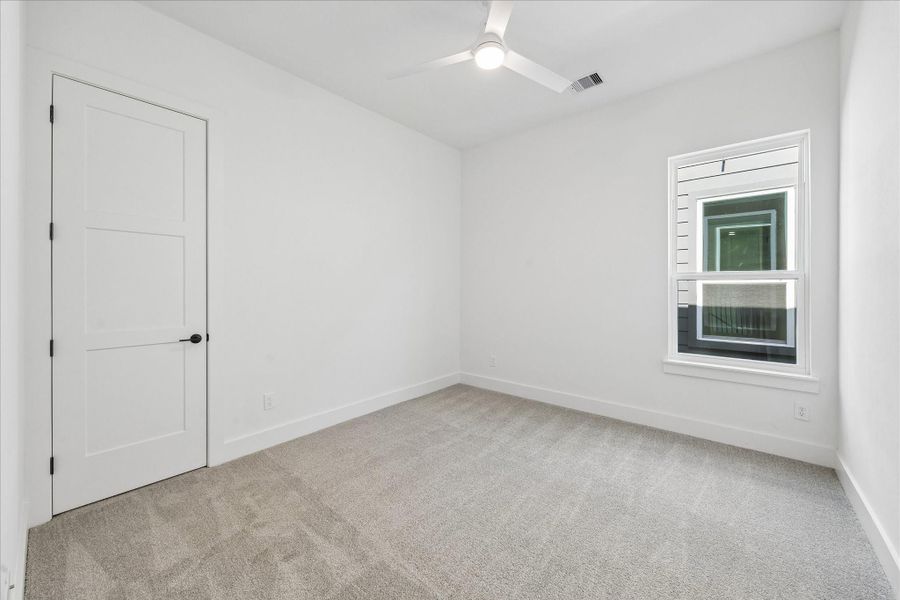 Large windows fill the room with natural light while offering flexible space for guests, family, or a home office.