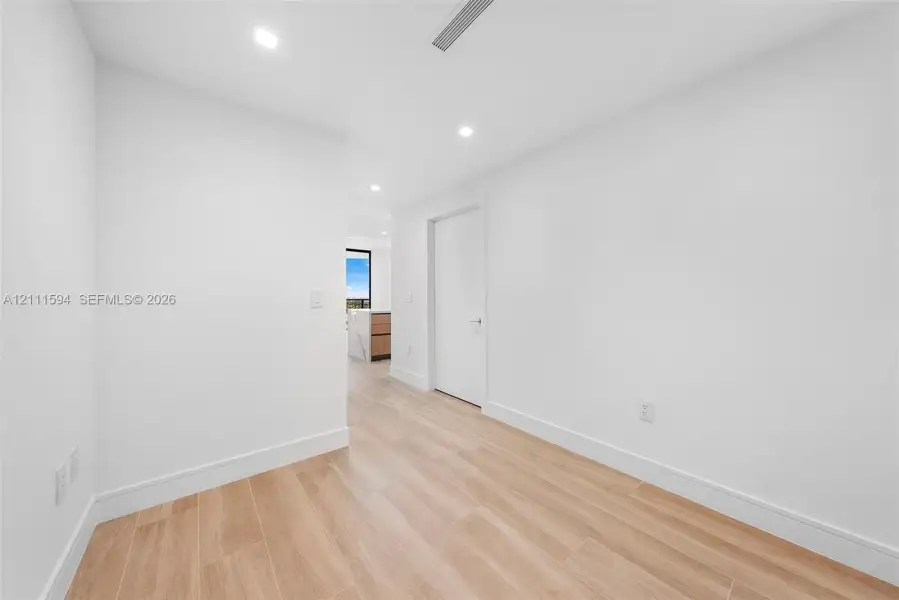 Interior space featuring wood-finish flooring, recessed lighting, and crisp white wall finishes Interior space featuring wood-finish flooring, recessed lighting, and crisp white wall finishes