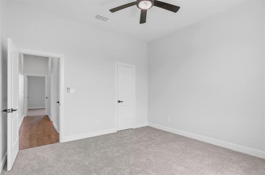 Unfurnished bedroom with a closet, carpet floors, and ceiling fan