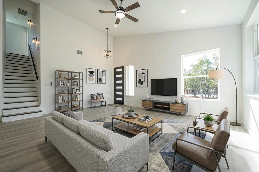High ceilings and a minimalist staircase anchor this airy living space with tall windows. High ceilings and a minimalist staircase anchor this airy living space with tall windows.