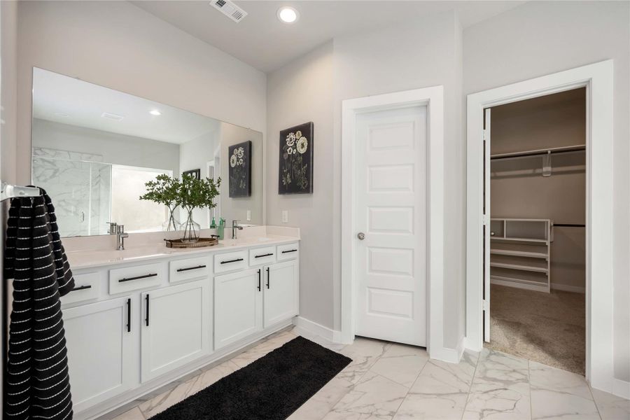Primary bath with dual vanities and granite counters. Primary bath with dual vanities and granite counters.