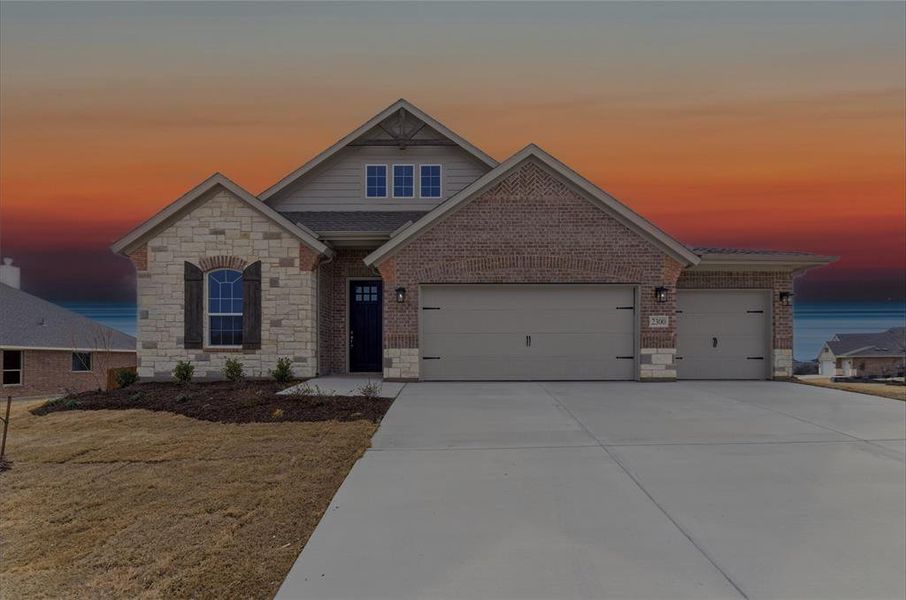 View of front facade featuring stone siding, concrete driveway, an attached garage, and brick siding