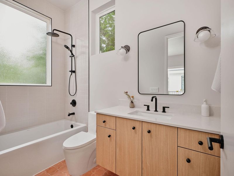 Bathroom featuring a light wood-finish vanity with a white countertop and integrated sink
