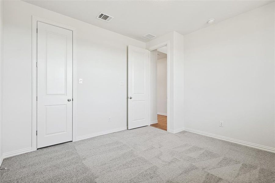 Unfurnished room featuring light colored carpet