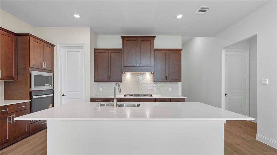 Kitchen island with a white countertop and undermount sink