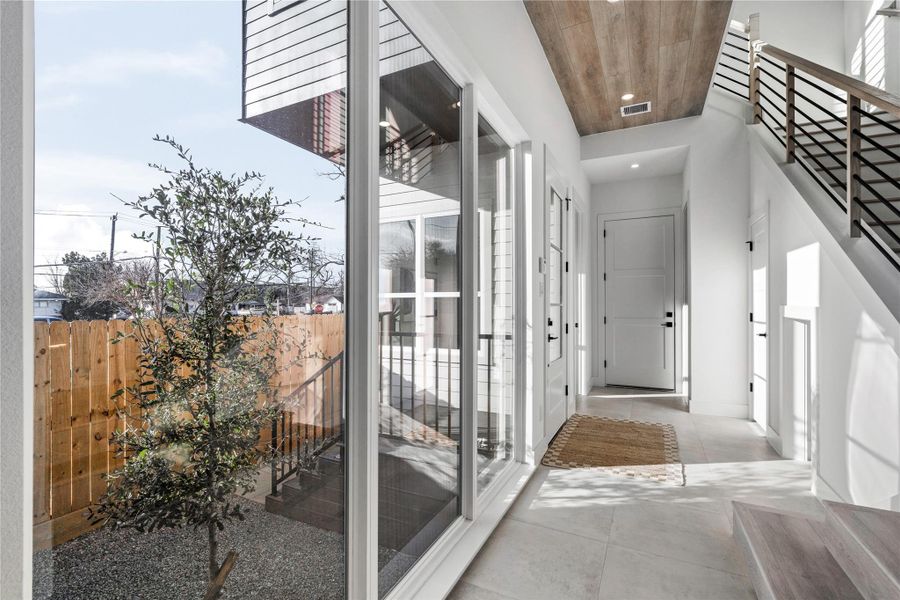 Daylight streams in from every angle, accentuating clean geometry and layered textures. It’s a transitional space that feels less like a hallway and more like an experience.