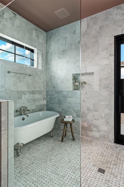 Full bath featuring plenty of natural light and a soaking tub