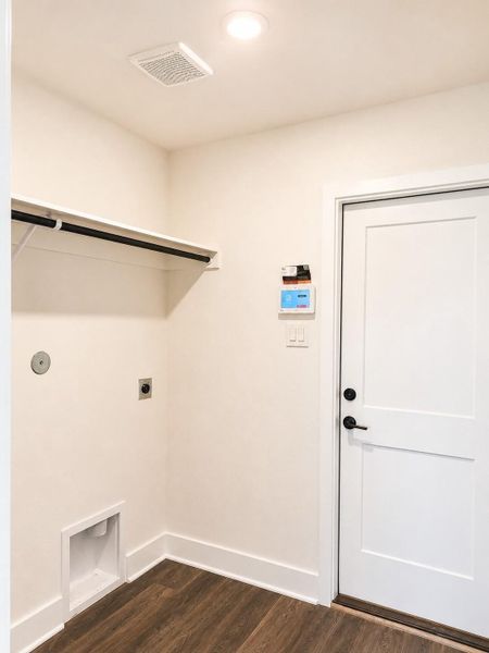 Functional utility space featuring modern finishes, built-in shelving, wood-look flooring, and convenient laundry connections. Functional utility space featuring modern finishes, built-in shelving, wood-look flooring, and convenient laundry connections.
