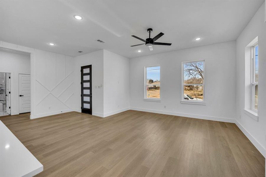 Unfurnished living room featuring ceiling fan and light hardwood / wood-style floors